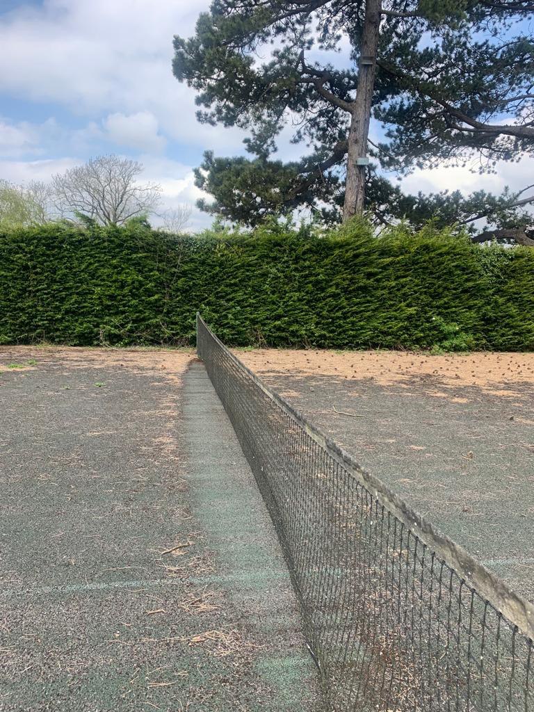 This is a photo of a tennis court in Hampshire that is in need of refurbishment